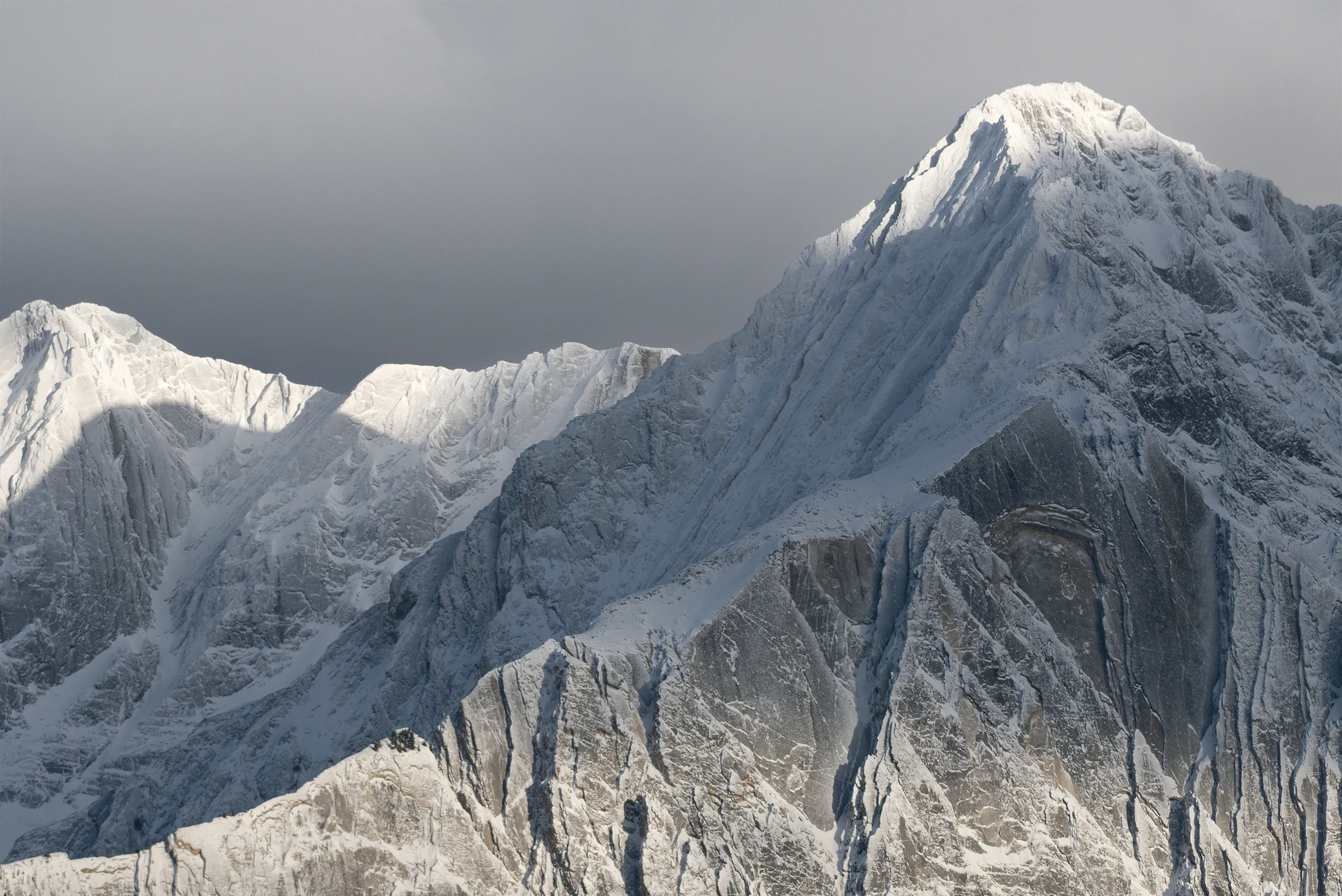 Close winter mountain detail with white snow and dark ridges.