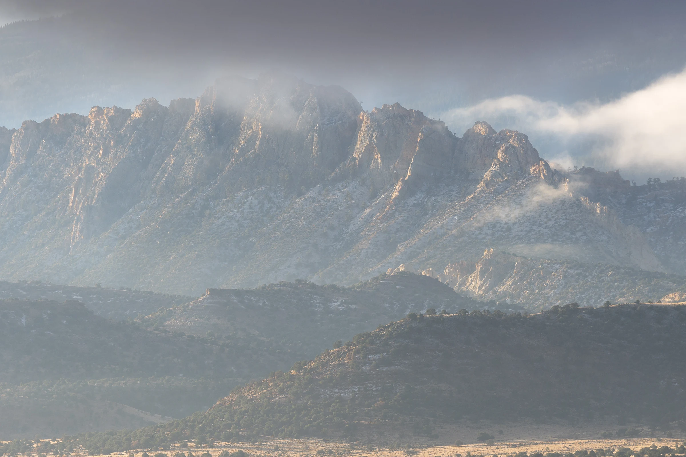 Snow-covered mountains rise beneath a cloudy sky.