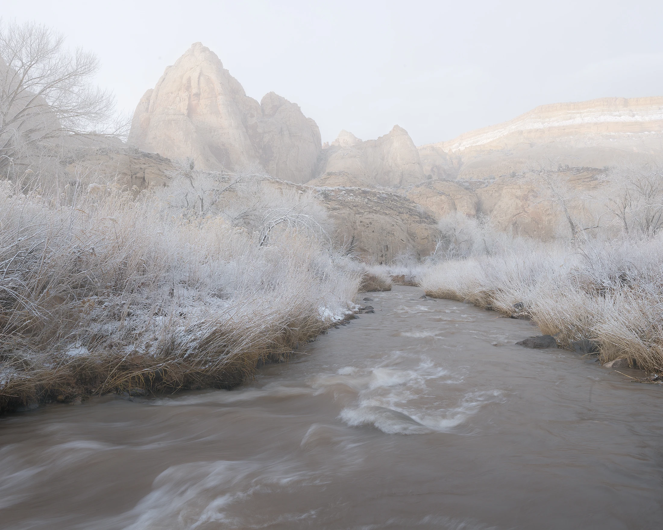 Snow-covered mountains rise beneath an open sky.