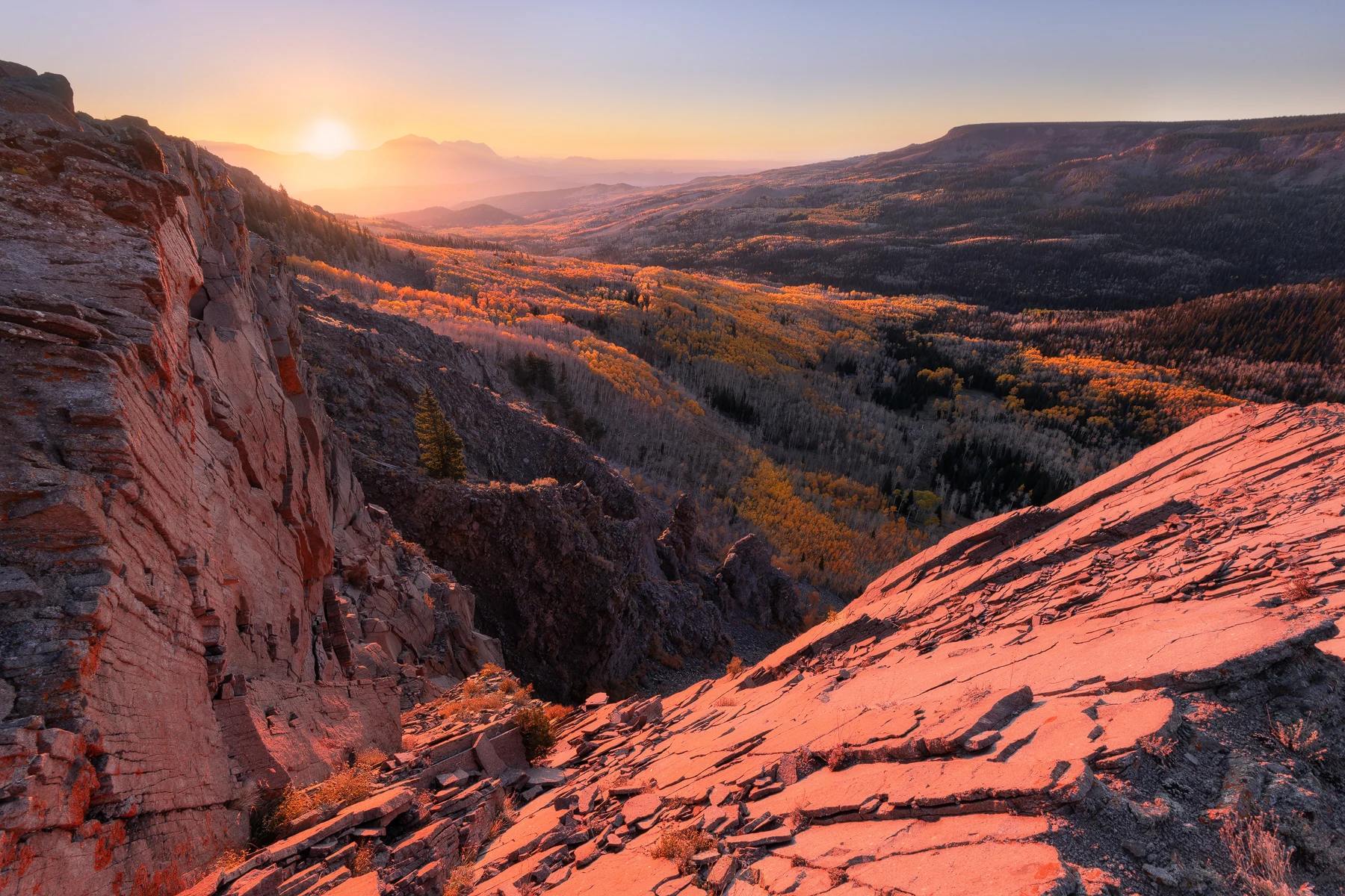 Warm light crosses sandstone cliffs in a canyon.