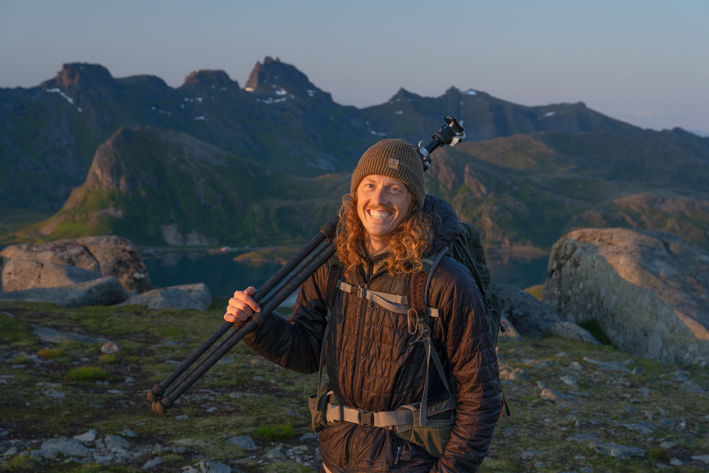 Hunter Page carrying a tripod while photographing in the mountains