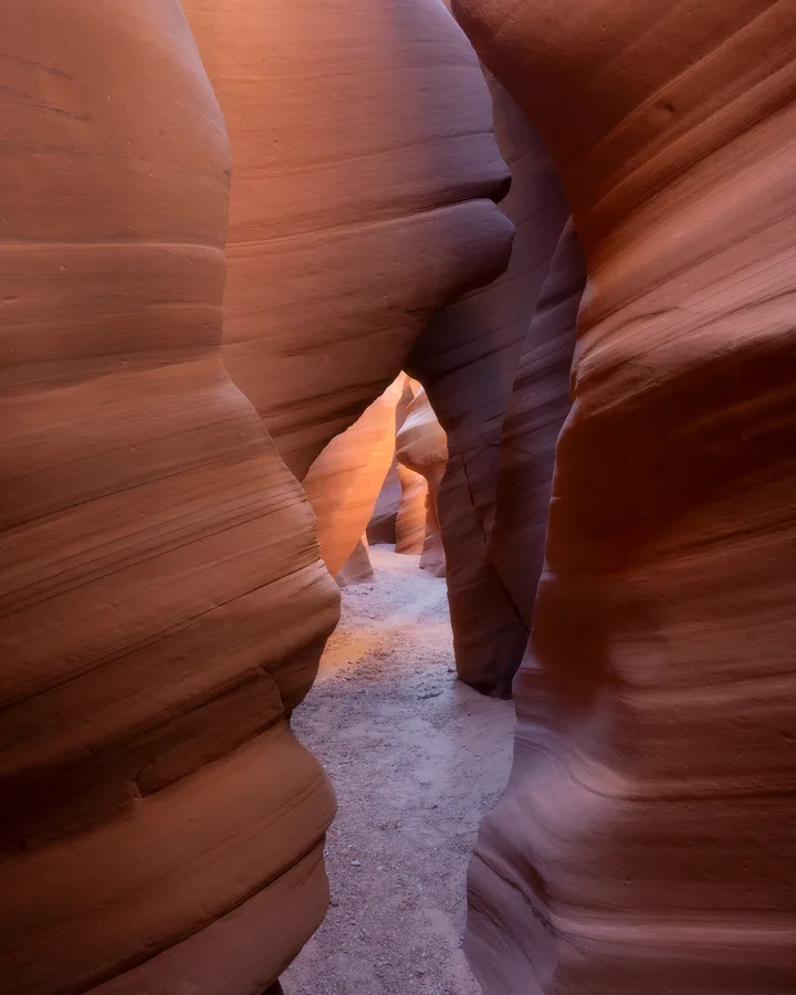 Vertical slot canyon with orange sandstone and cool blue shadow.