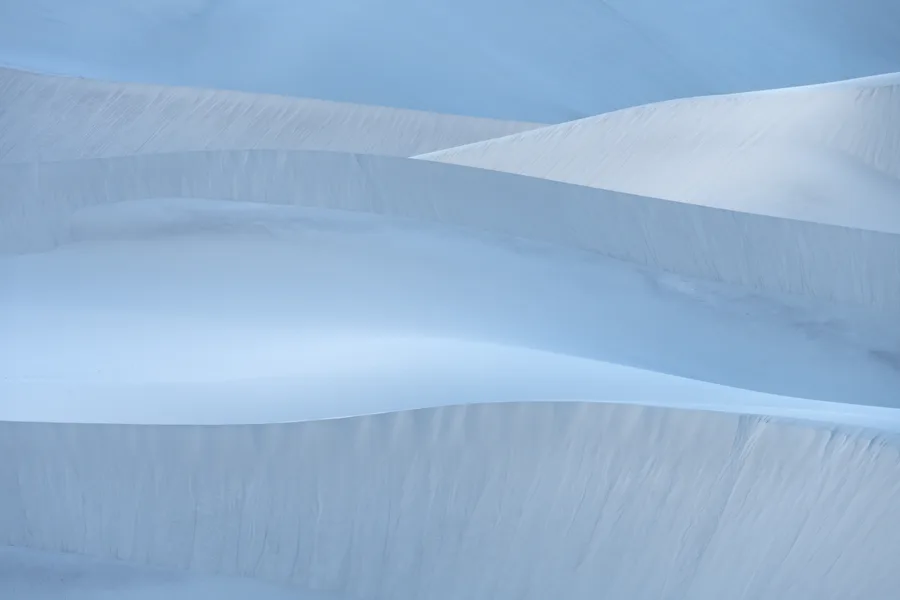 Wind-sculpted sand dunes stretch beneath an open sky.