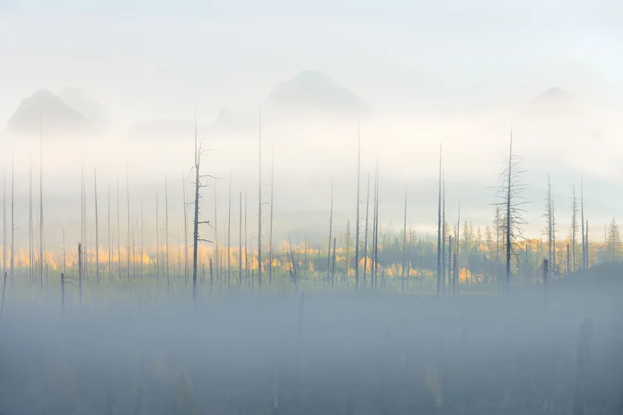 A misty mountain lake beneath rugged peaks.