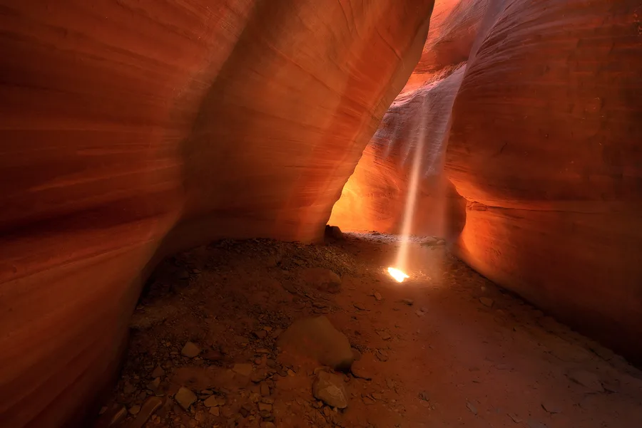 Narrow slot canyon with a bright golden beam of light.
