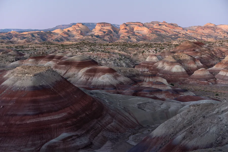 Layered red and white badlands under soft desert light.