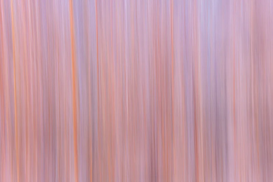 Soft vertical pink and lavender abstract motion blur.