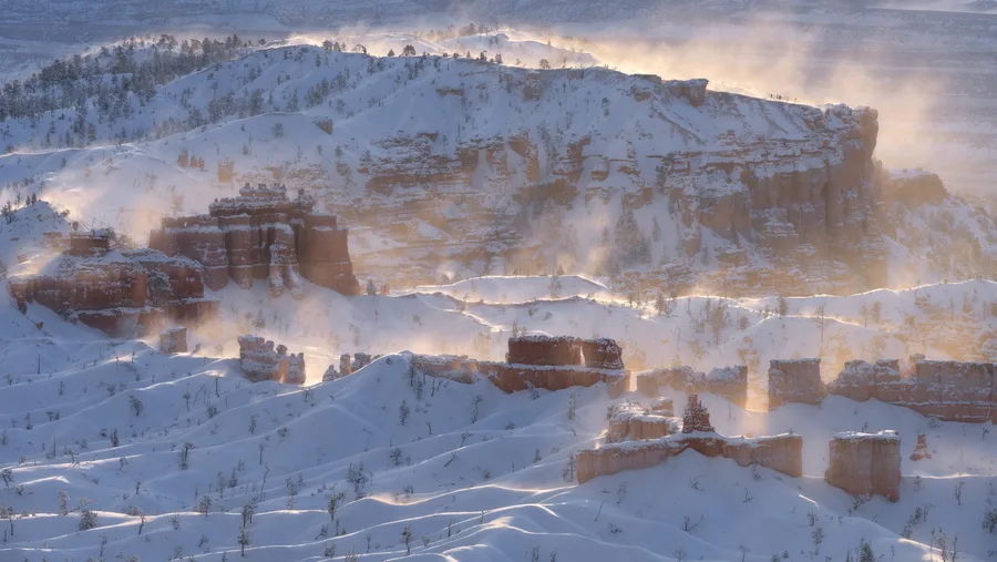 Snow-covered mountains rise beneath storm clouds.