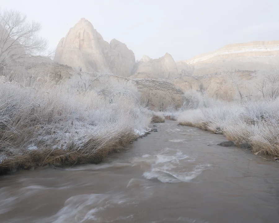 Snow-covered mountains rise beneath an open sky.