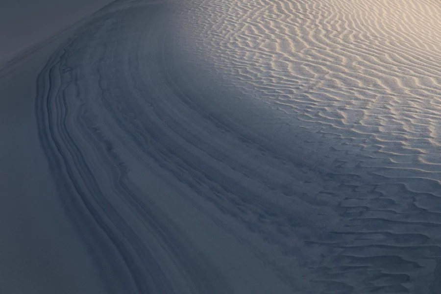 Minimal Death Valley sand dune with soft gray-blue curves.