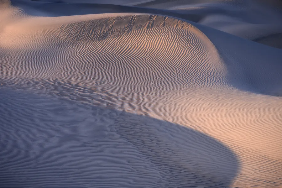 Patterns and shapes and lines in sand dunes of light at sunset