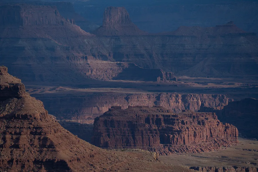 Layered sandstone cliffs in a canyon.