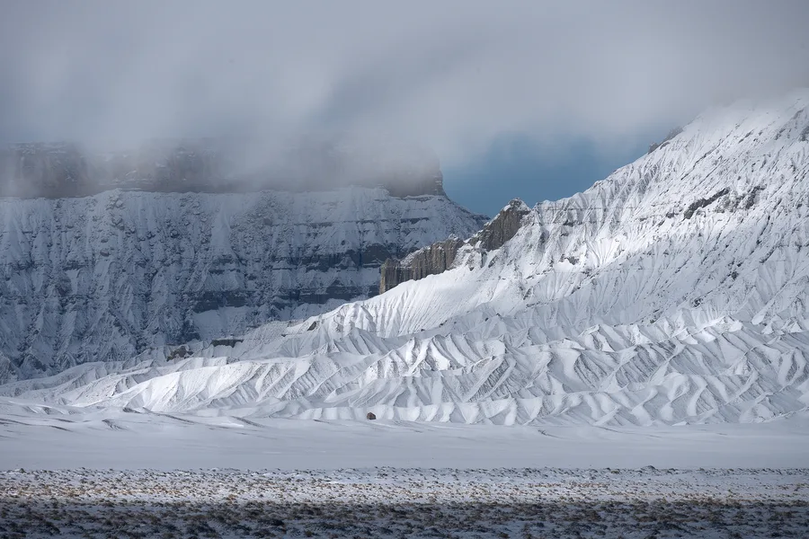 Snow-covered mountains rise beneath a cloudy sky.