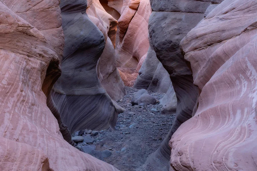 Pink and blue slot canyon walls with flowing sandstone curves.