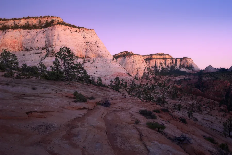 Pale sandstone cliffs under a purple dusk sky.