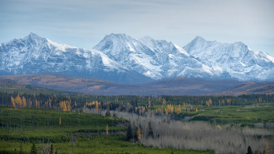 Snow-covered mountains rise beneath a cloudy sky.