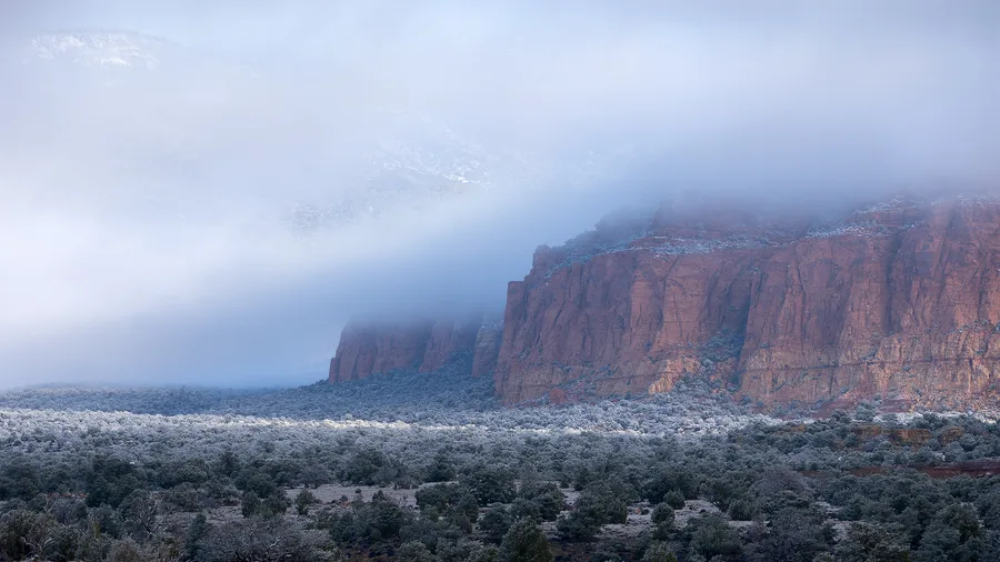 Weathered rock cliffs emerging through mist.