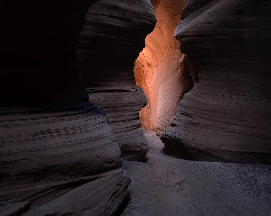 Warm light entering a dark narrow slot canyon.